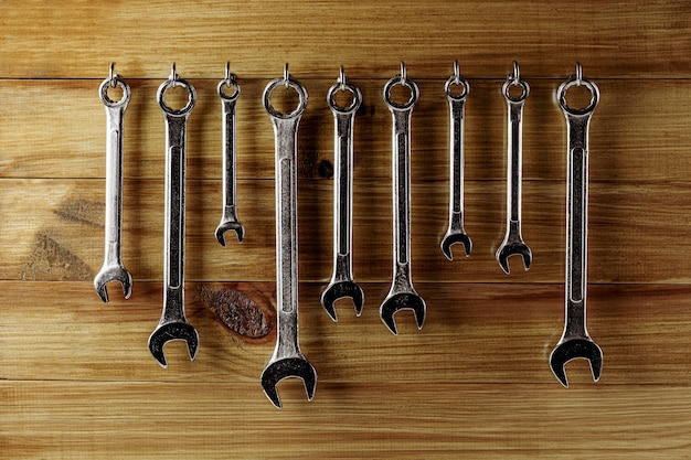 Reeks van moersleutel het hangen bij oude houten muur. industriële werkplaats handgereedschap.