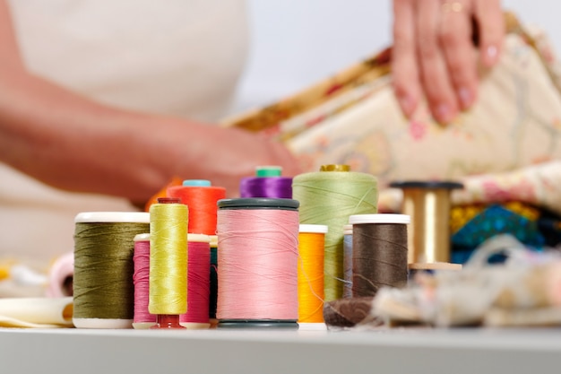 Reels of colored threads, seamstress at the bottom