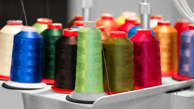 Катушки текстильной пряжи синей нитью на промышленном ткацком станке