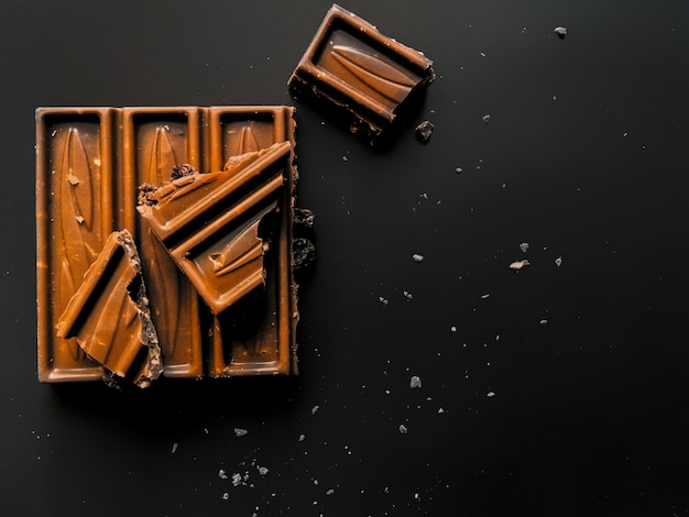 Foto reep melkchocola met verpletterde geïsoleerde hazelnoot en alcoholrozijnen