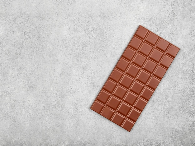 Reep melkchocolade op grijze stenen achtergrond Bovenaanzicht met kopieerruimte