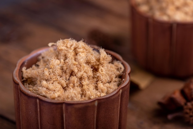 The refined meat floss is in the cup in the dark background