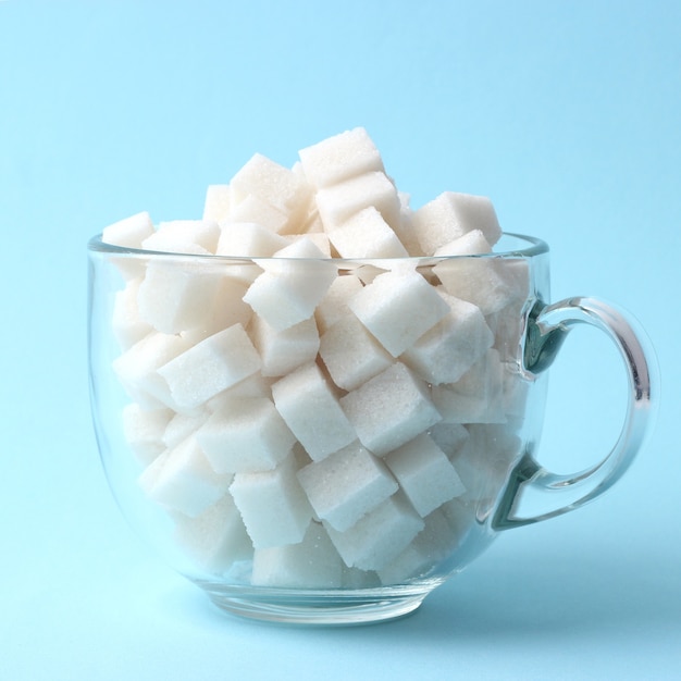 Refined sugar in a glass on a colored background diabetes concept excess sugar