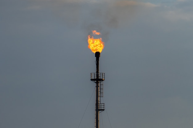 Refinery fire gas torch against the gray sky