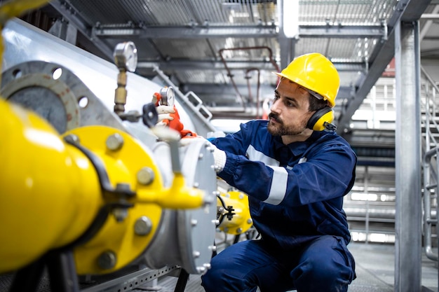 Refinery operator standing by pipes and controlling natural gas supply and distribution