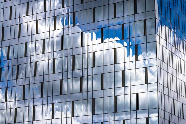 Reflectie in de blauwe lucht van het gebouw met lichte wolken