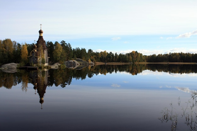 Reflectie van bomen in het meer tegen de lucht