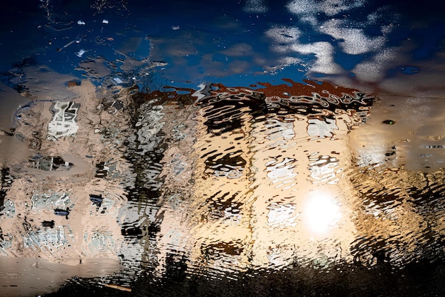 Reflectie van de hemel op een nat glasraam