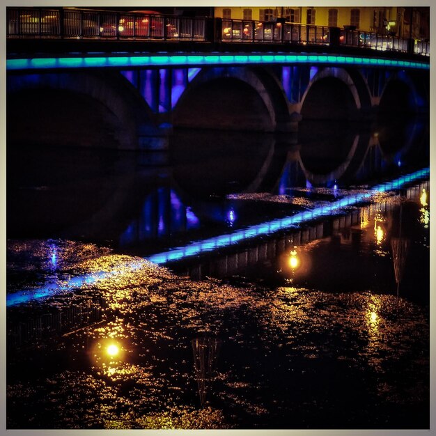 Foto reflectie van een verlichte brug op de rivier's nachts