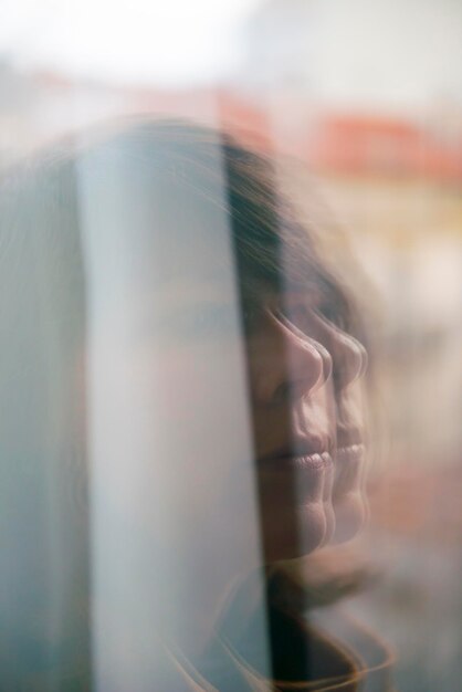 Foto reflectie van een volwassen vrouw op het raam.