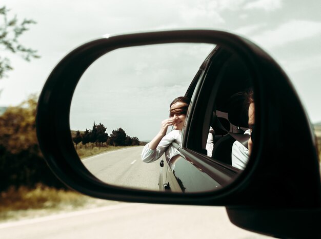 Foto reflectie van een vrouw in een auto in de zijspiegel