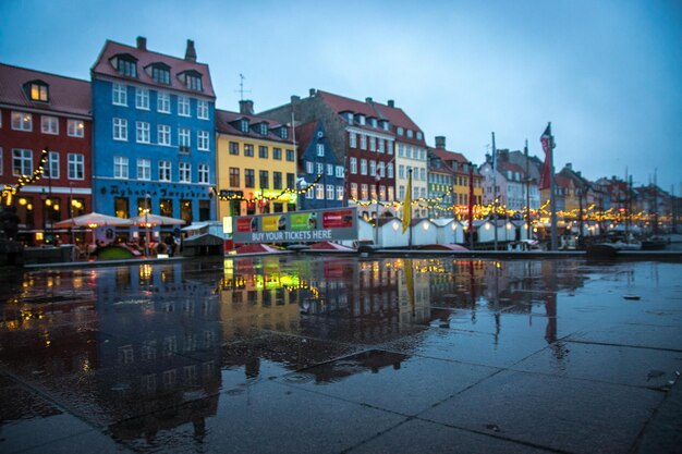 Foto reflectie van gebouwen op natte straat in de stad in de schemering