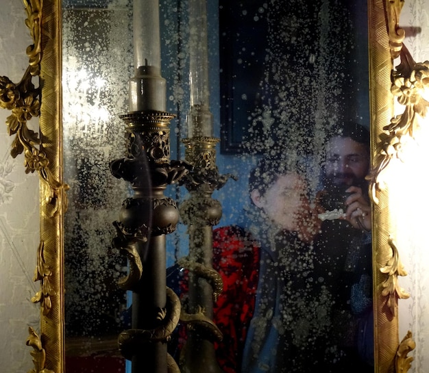 Foto reflectie van man en vrouw op een decoratieve spiegel thuis