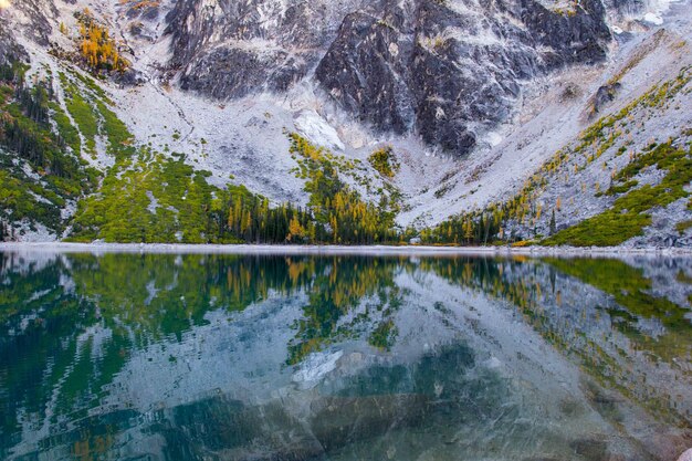 Foto reflectie van rotsachtige bergen in een rustig meer