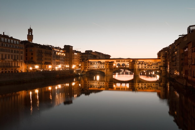 Reflectie van verlichte gebouwen en de ponte vecchio brug in Florence, Italië