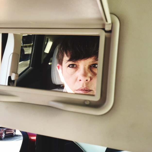 Reflectie van vrouw in auto op spiegel