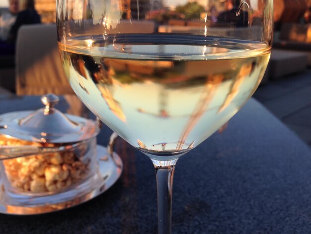 Foto reflecties van gebouwen in wijnglas op tafel in een restaurant