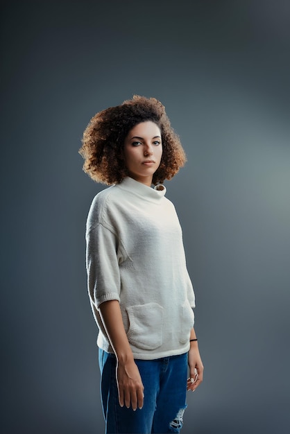 Reflectieve en rustige de vrouwen zachte blik en krullend haar vertellen een verhaal van stille kracht