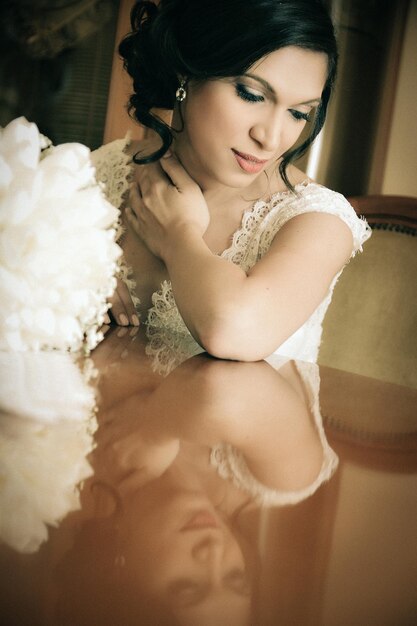 Reflection of bride with bouquet on table