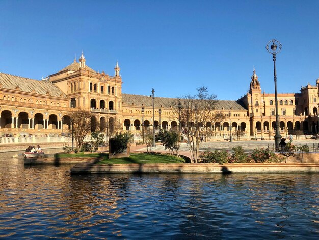 Reflection of building in lake against clear sky