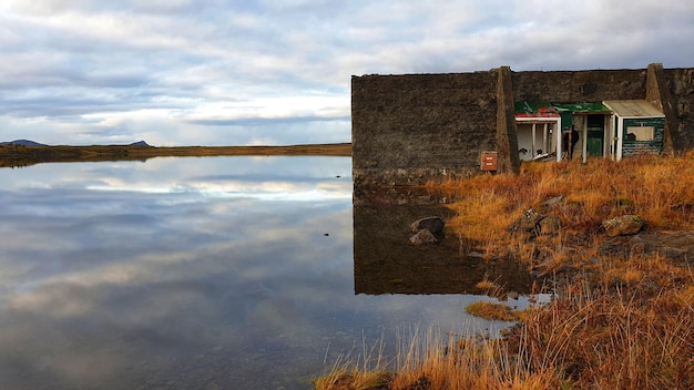 Photo reflection of building on lake against sky