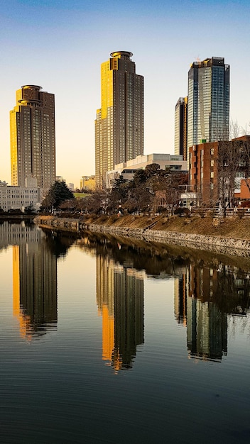 Photo reflection of buildings in city against clear sky