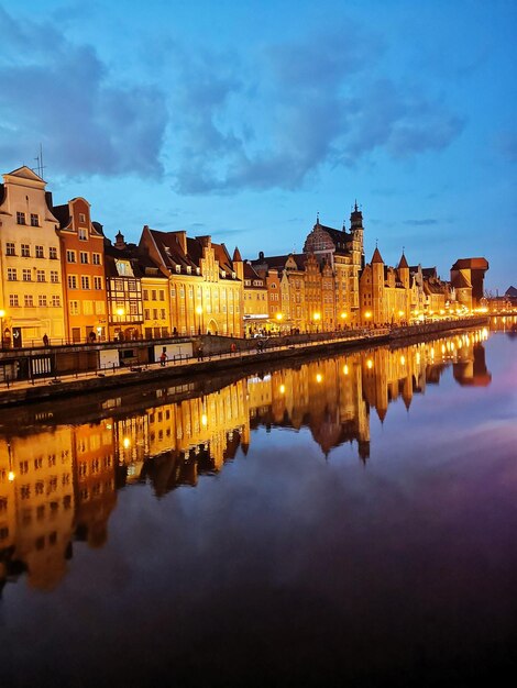 Reflection of buildings in lake at dusk