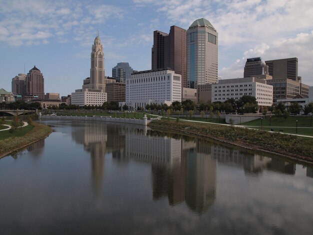 Photo reflection of buildings in river against sky