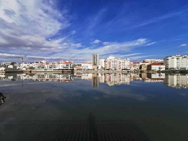 Reflection of buildings in river against sky