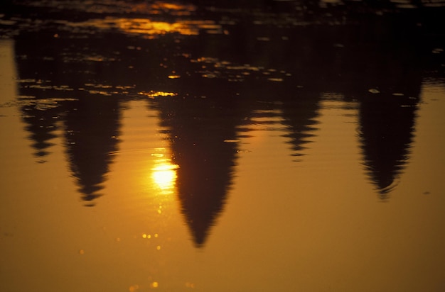 Photo reflection of buildings and sun in lake