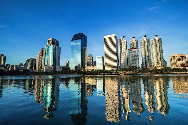 Reflection of buildings in swimming pool against blue sky