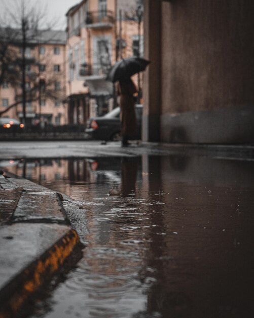 Foto riflessione degli edifici sulla strada bagnata nella stagione delle piogge