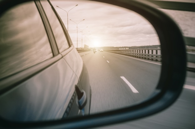 Reflection in the car rear view mirror and the road light.