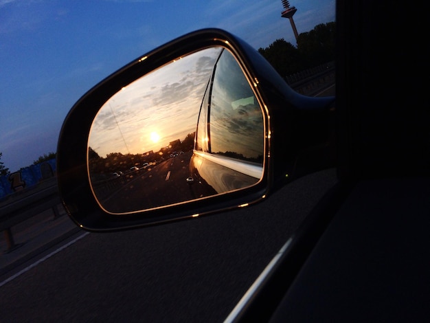 Reflection of car on road at sunset