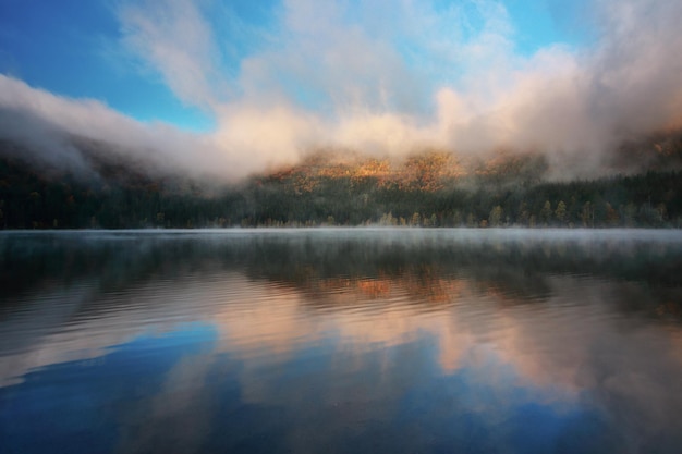 Photo reflection of clouds in calm lake