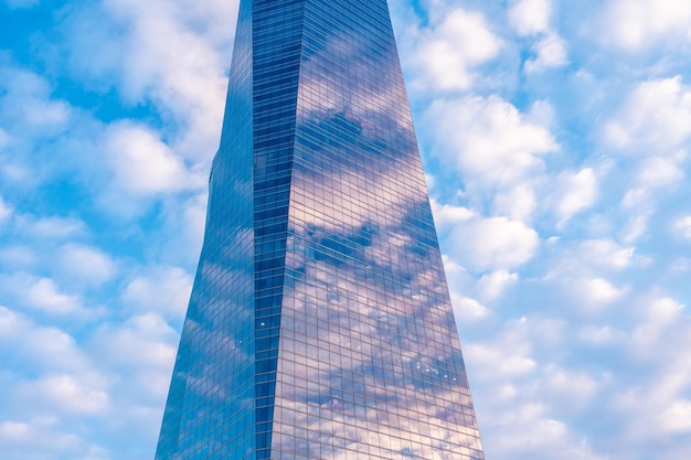 Reflection of clouds in a glass building financial area seen from below at sunrise modern office building