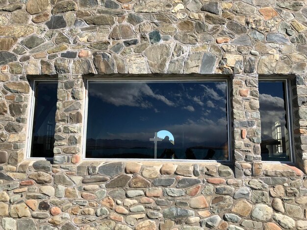 Photo reflection of clouds in windows of a building with a cross inside