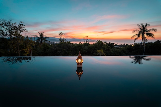 reflection of decoration in swimming pool against sky during sunset