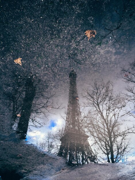 Photo reflection of eiffel tower on puddle during monsoon