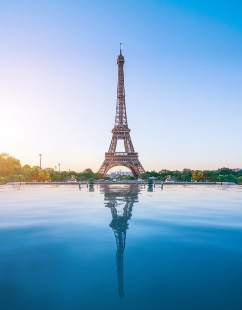 Reflection of eiffel tower in river against sky