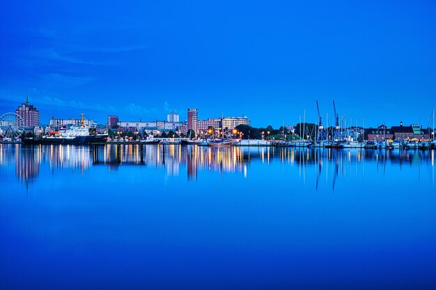 Foto il riflesso della fabbrica nel porto contro il cielo blu