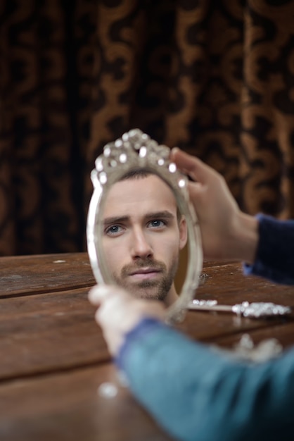 Reflection of fashion model men in the mirror. Portrait of handsome young man looking into mirror