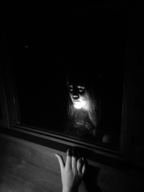 Photo reflection of girl in dark room