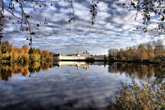 reflection of historic building on lake against cloudy sky