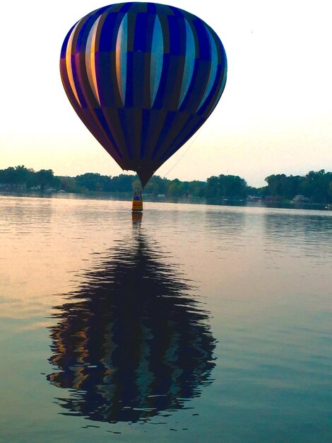 Foto riflessione di una mongolfiera nel lago