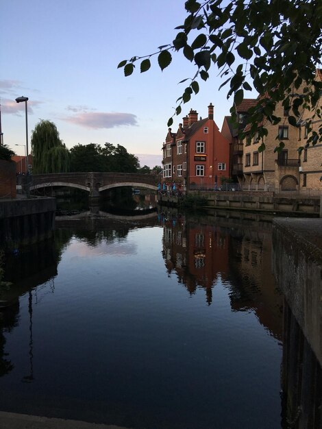 Reflection of houses in lake against sky