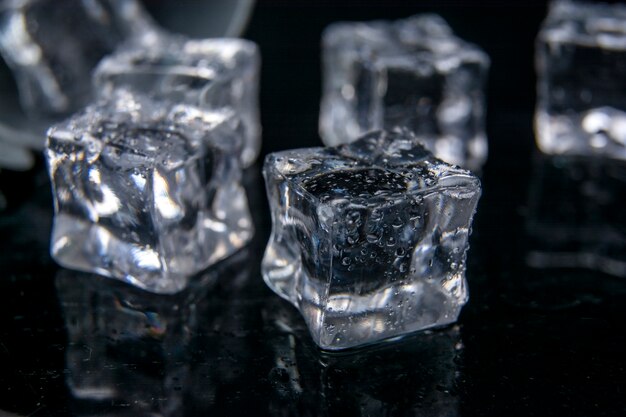 Reflection of ice cubes on the black background of the table