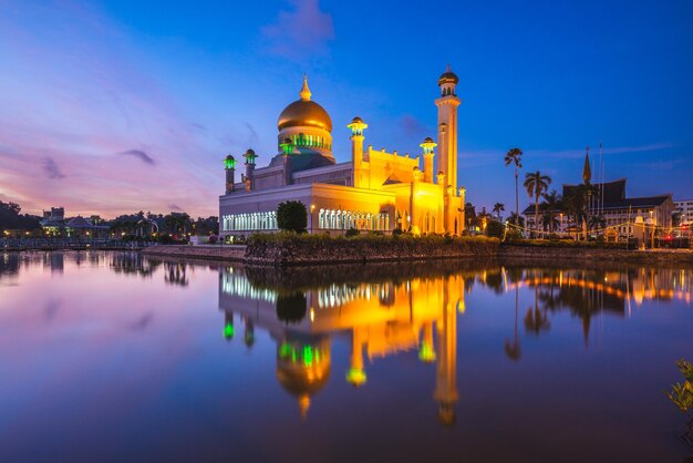 Reflection of illuminated building in lake against sky