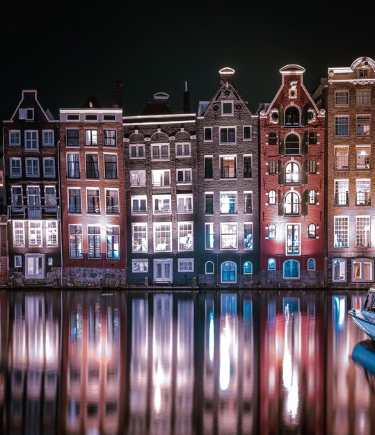 Reflection of illuminated buildings in city at night amsterdam