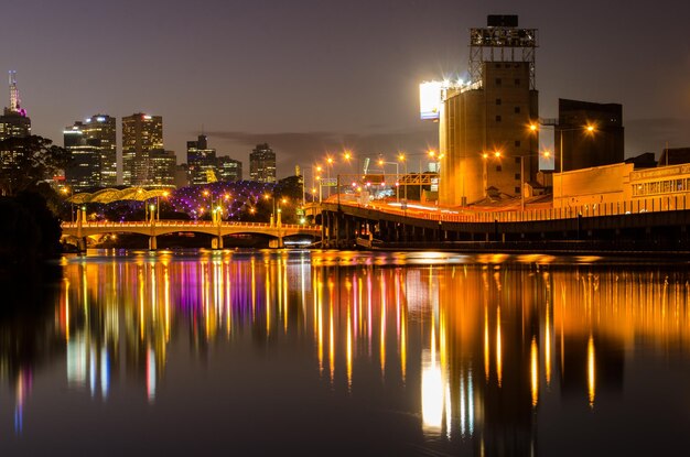 Foto riflessione di strutture costruite illuminate nel fiume